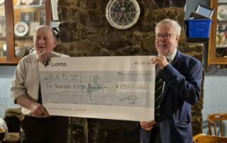 RABI Trustee Delme Harris accepting a cheque of £250 from the Welsh Black Cattle Society's Vice Chairman Robert Morgan