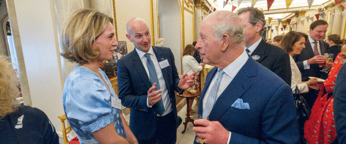 Hugh and Alex Addison speaking with His Majesty The King at a reception at Buckingham Palace