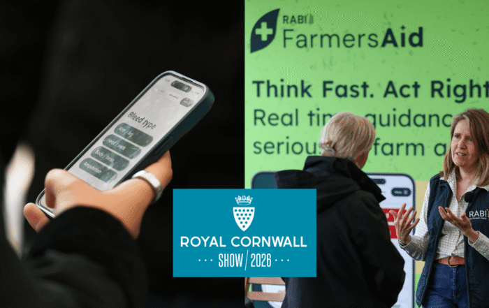 A Royal Cornwall Show 2026 promotional banner featuring FarmersAid. On the left, a person holds a smartphone displaying the FarmersAid app. On the right, a RABI representative speaks with a visitor in front of a large FarmersAid display board showing the slogan “Think Fast. Act Right.” and information about real-time guidance for serious on-farm accidents. The Royal Cornwall Show 2026 logo is positioned centrally across the image.