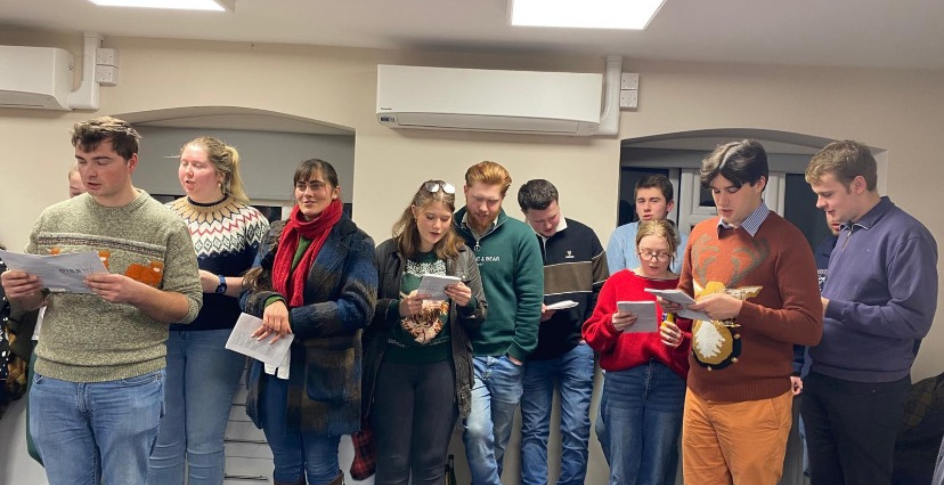 Members of Diss Young Farmers' Club standing up singing Christmas carols