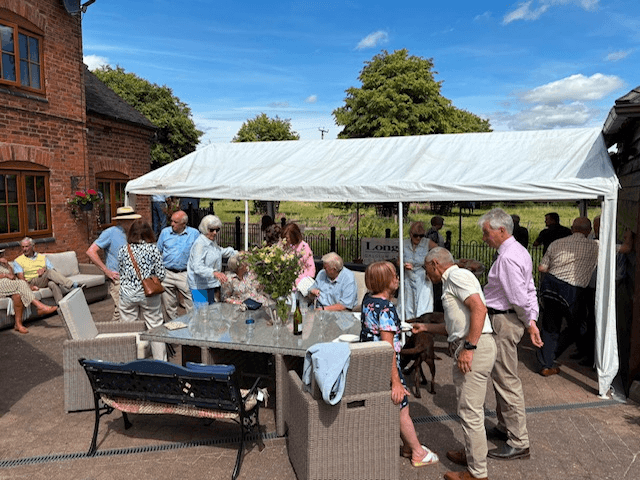 Guests gathering and socialising outdoors beneath a marquee at the RABI Leicestershire Summer Party 2026.
